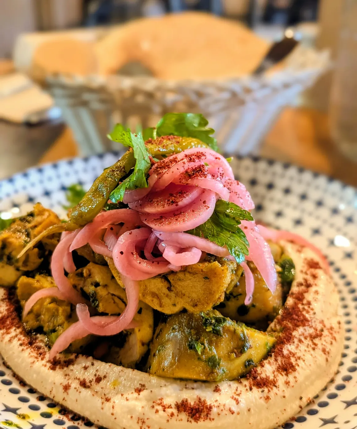 Moroccan chicken on creamy hummus, topped with pickled red onion and fresh parsley